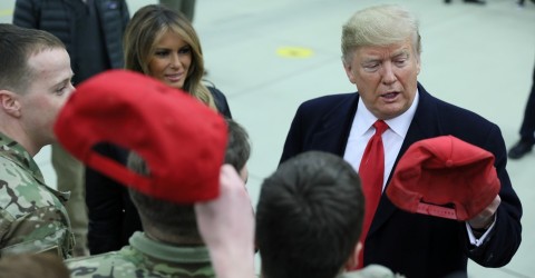 Donald Trump holds a cap while visiting U.S. troops at Ramstein Air Base in Germany on December 27. Photo: Jonathan Ernst / Reuters