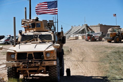 A US soldier sits on an armored vehicle at a newly-installed position in Manbij, Syria, in April 2018. Photo: Hussein Malla/AP/File