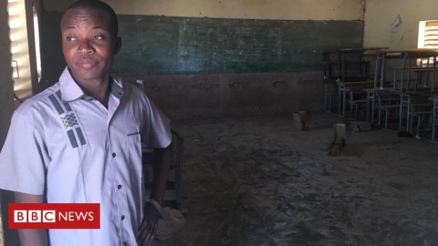 Desks and chairs are piled up in the corner of a school with no children. On the blackboard, the date has been written down: 15 December 2018.