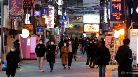 file-photo--people-wearing-face-masks-to-protect-themselves-against-contracting-the-new-coronavirus-walk-on-a-street-in-central-seoul-4