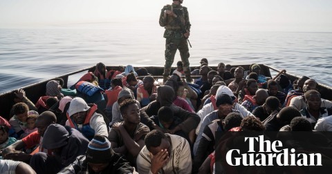 A Libyan coastguardsman stands on a boat carrying migrants off the coastal town of Zawiyah. Photograph: Taha Jawashi/AFP/Getty Images