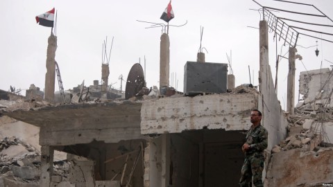 A Syrian army soldier stands at a damaged site in al-Hajar al-Aswad neigborhood, which was recaptured from Islamic State group militants on Monday. May 22, 2018. Photo: Reuters