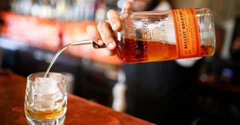 A bartender pours a glass of bourbon whiskey at the World's End pub in London on June 22, 2018. Photo: Henry Nicholls / Reuters 