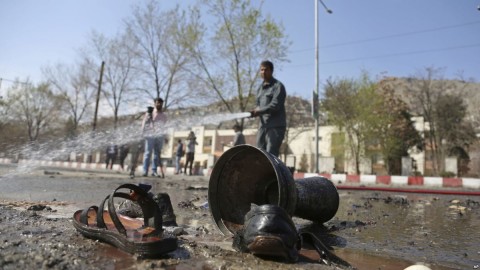 Afghan firefighters clean up the site of a deadly suicide bombing near Kabul University, in Kabul, March 21, 2018. Photo: AP