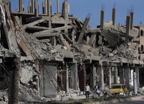 In this April 5, 2018, file photo, rubble of buildings line a street that was damaged during fighting between U.S.-backed Syrian Democratic Forces fighters and Islamic State militants, in Raqqa, Syria. AP Photo/Hussein Malla