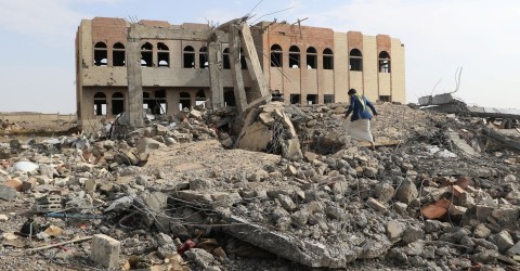 A man walks through the rubble of an airstrike on a college in Saada, Yemen. Photo: Naif Rahma / Reuters