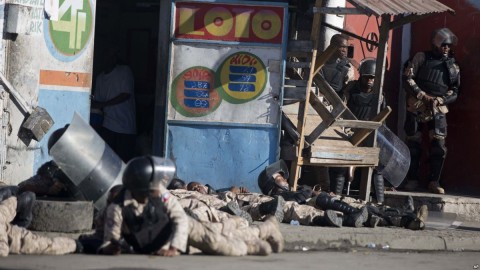 National police take cover as gunshots ring out at the end of a ceremony marking the 212th anniversary of the assassination of independence hero Gen. Jean-Jacques Dessalines in Port-au-Prince, Haiti, Oct. 17, 2018. Photo: AP