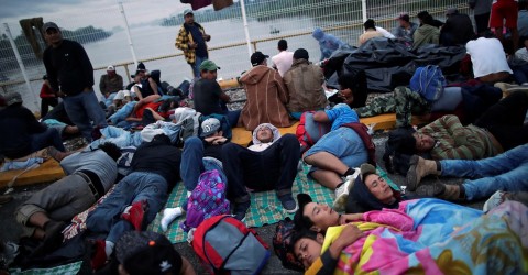 Honduran migrants, part of the caravan trying to reach the US, wait to open the gate on the bridge that connects Mexico and Guatemala on October 20, 2018. Photo: Ueslei Marcelino / Reuters